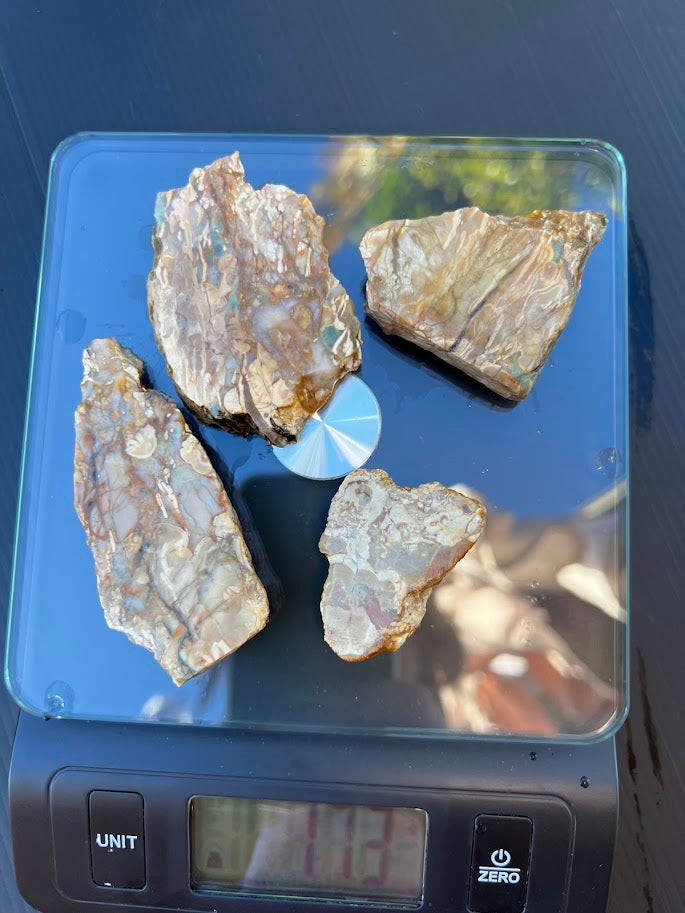 Set of four raw chalcedony agate nodule pieces on a scale showing 1261g total weight